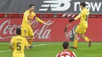 Striker Barcelona, Lionel Messi (kiri) melakukan selebrasi bersama gelandang Pedri usai mencetak gol kedua timnya ke gawang Athletic Bilbao dalam laga lanjutan Liga Spanyol 2020/21 di San Mames Stadium, Bilbao, Rabu (6/1/2021). Barcelona menang 3-2 atas Athletic Bilbao. (AFP/Ander Gillenea)