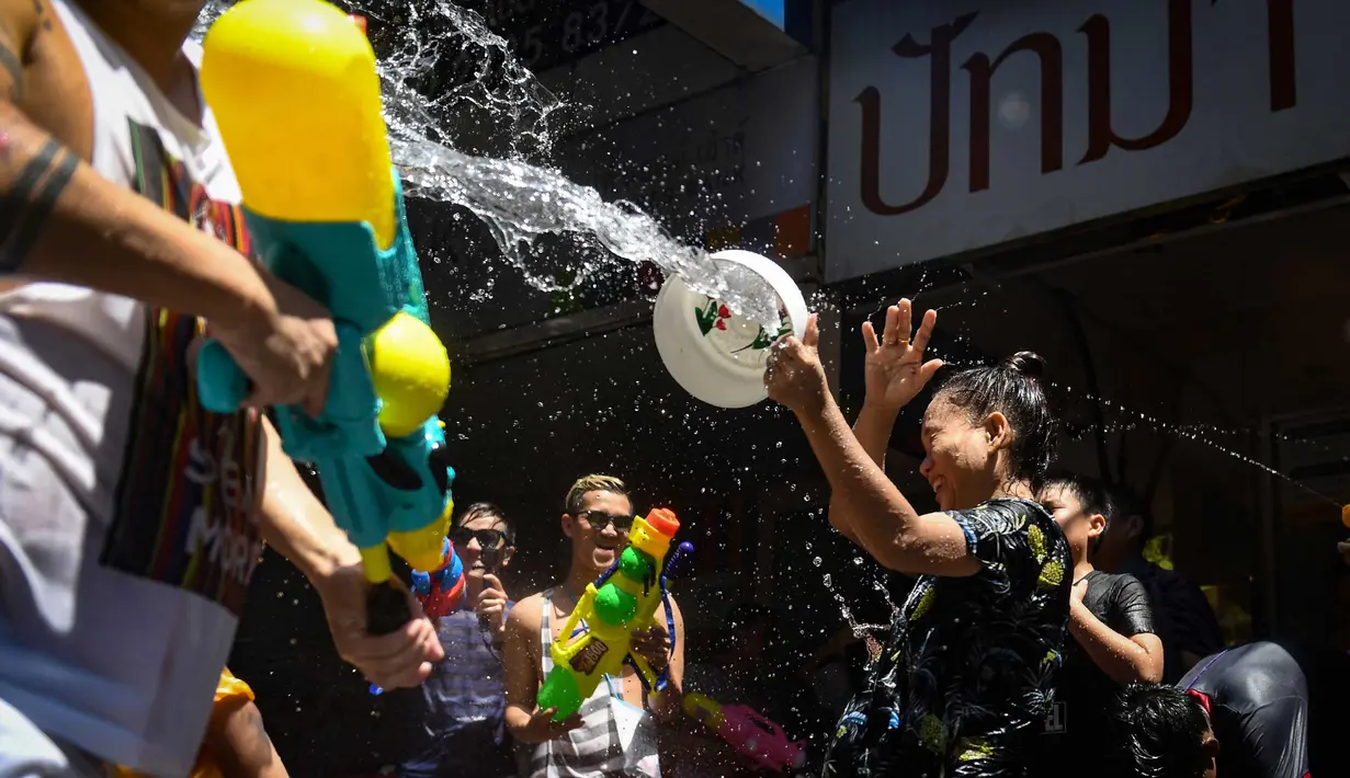 Keseruan orang-orang saling menyemprotkan air selama Festival Songkran di Silom Road, Bangkok, Jumat (13/4). Selama tiga hari, di bulan terpanas dalam setahun, Thailand menjadi penyelenggara festival air terbesar di dunia ini. (LILLIAN SUWANRUMPHA/AFP)
