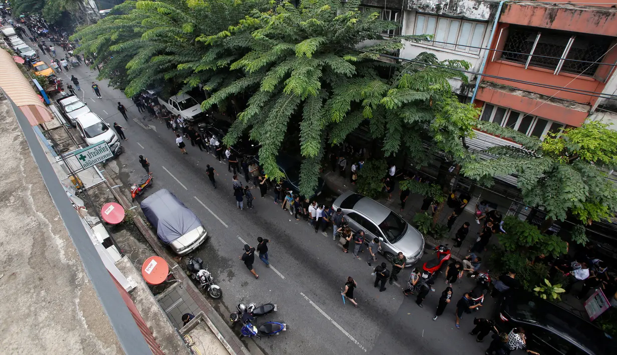 Barisan antrien warga yang terlihat di dekat kantor pusat Bank Tabungan Pemerintah di Bangkok, Thailand (18/10). Warga Thailand mengantre untuk mendapatkan uang kertas 100 baht edisi ulang tahun Raja Bhumibol ke-84. (Reuters/Edgar Su)