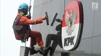 Pekerja membersihkan debu yang menempel pada tembok dan logo KPK di Gedung KPK, Jakarta, Rabu (21/11). Pemerintahan Provinsi Papua mendapat skor terendah yaitu 52,91. (Merdeka.com/Dwi Narwoko)