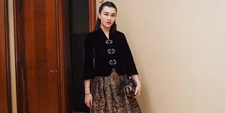 Tampilan glamor Aaliyah kenakan kebaya velvet hitam yang dipadukan rok batik jacquard yang mewah. Semakin elegan dengan aksesori emas di kepalanya. [@aaliyah.massaid].