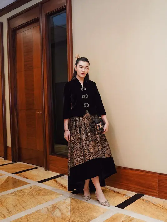 Aaliyah Massaid menyempurnakan penampilannya dengan gaya rambut half-ponytail yang dipermanis dengan tusuk konde emas. Aaliyah juga tampil menenteng clutch yang serasi dengan penampilannya. [Foto: Instagram/aaliyah.massaid]