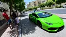 Direktur Pelaksana Pakistan Supermarket Dubai Muhammad Jehanzeb mengendarai Lamborghini Huracan usai mengirim pesanan mangga di Dubai, Uni Emirat Arab, Kamis (2/7/2020). Supermarket tersebut mengantarkan pesanan mangga untuk minimal pesanan sekitar USD 27. (CACACE GIUSEPPE/AFP)