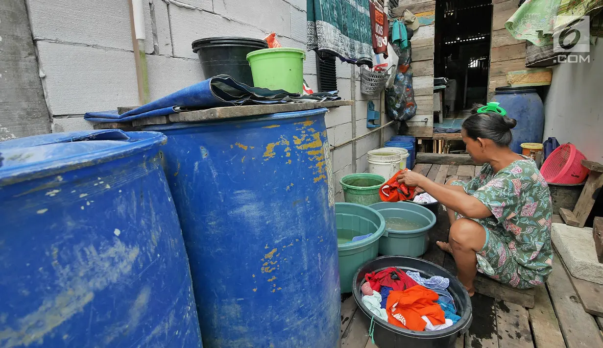 Warga mencuci pakaian di kawasan Kampung Kamal Muara, Jakarta, Selasa (9/7/2019). Saat musim kemarau, warga Kampung Kamal Muara harus membeli air seharga Rp 5.000 per jeriken untuk kebutuhan mandi, cuci pakaian dan lain-lain. (Liputan6.com/Herman Zakharia)