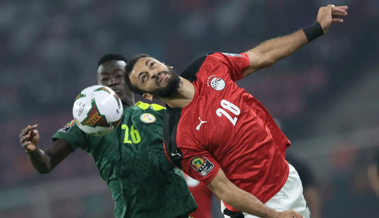 Striker Mesir, Marwan Hamdi (kanan) berduel udara dengan gelandang Senegal, Pape Gueye dalam laga final Piala Afrika 2021 di Stade d'Olembe, Yaounde, Kamerun (6/2/2022). (AFP/Kenzo Tribouillard)