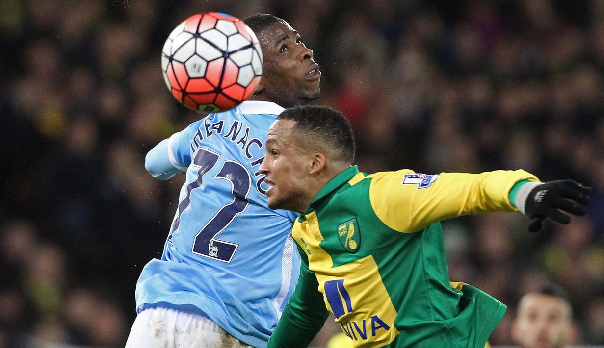 Pemain Manchester City, Kelechi Iheanacho (kiri) berebut bola dengan pemain Norwich City, Martin Olsson pada laga Babak ketiga Piala FA di Stadion Carrow Road, Norwich, Sabtu (9/1/2016). (AFP Photo/Lindsey Parnaby)