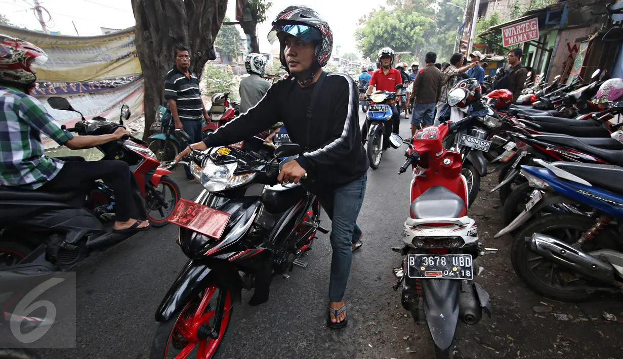 Pengendara motor menuntun kendaraan mereka usai motornya terkena operasi cabut pentil di Jalan Kyai Tapa, Roxy, Jakarta, (23/10/2015). Dengan banyaknya operasi cabut pentil sejumlah juru tambal mandapat tambahan rezeki. (Liputan6.com/Immanuel Antonius)
