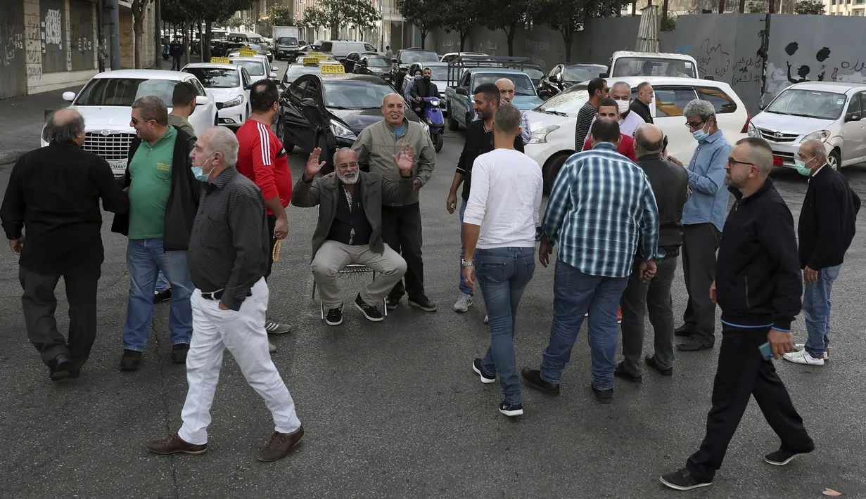 Pengemudi taksi memblokir jalan dengan kendaraan mereka selama aksi protes di pusat kota Beirut, Lebanon, Selasa (30/11/2021). Mereka memprotes kenaikan harga bensin, barang-barang konsumsi dan jatuhnya mata uang pound Lebanon. (AP Photo/Bilal Hussein)