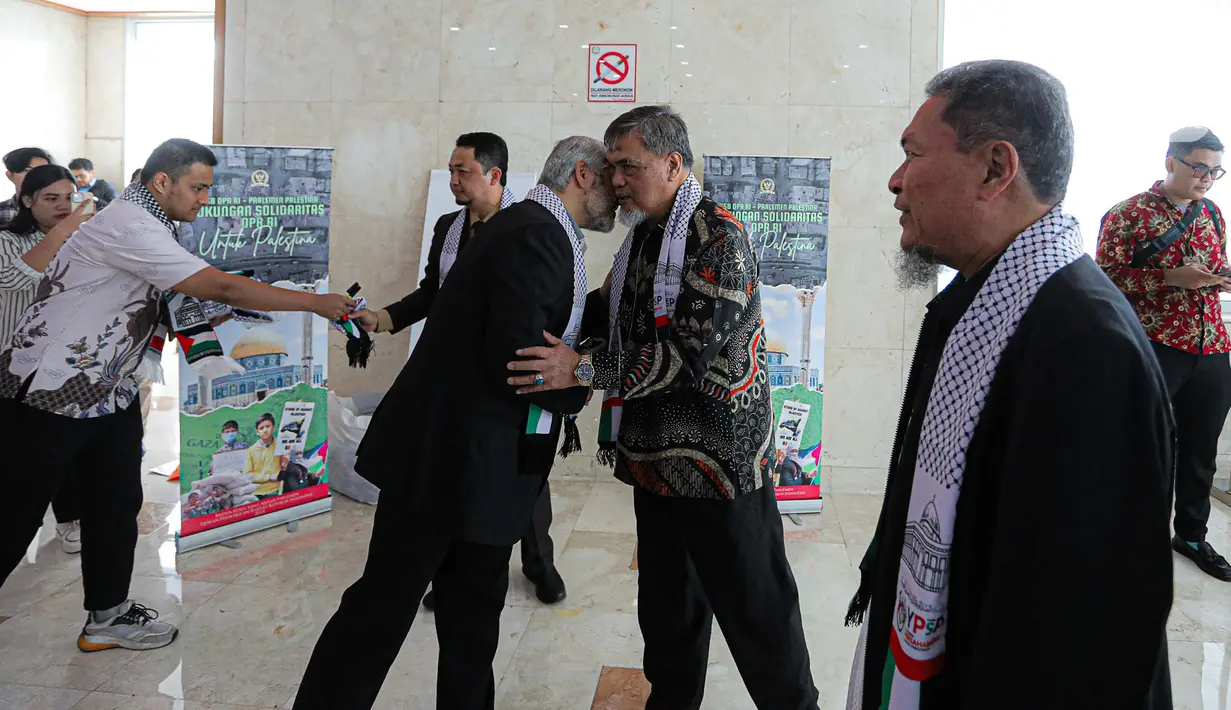 Direktur YPSP Ahed Abo Al Atta tampak membagikan syal kepada para anggota DPR. Dia tampak mengalungkan syal tersebut kepada setiap anggota yang hendak memasuki ruang Rapat Paripurna. (Liputan6.com/Faizal Fanani)