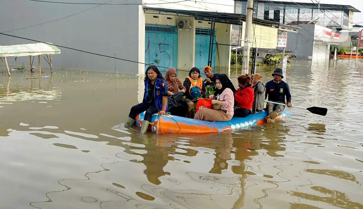 Warga menggunakan perahu karet melintasi banjir yang melanda Perumahan Total Persada, Periuk, Kota Tangerang, Selasa (4/2/2020). Banjir akibat tanggul kali Ledug jebol membuat ratusan rumah di Total Persada terendam banjir hingga mencapai 3,5 meter. (merdeka.com/Arie Basuki)