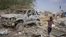 Seorang anak laki-laki berlari melewati puing-puing kendaraan yang hancur dalam serangan terhadap polisi dan pos pemeriksaan di pinggiran ibu kota Mogadishu, Somalia (16/2/2022). Serangan oleh kelompok ekstremis al-Shabab menewaskan lima orang dan melukai 16 orang. (AP Photo/Farah Abdi Warsameh)