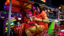 Wanita berbusana China menaiki tuk-tuk tradisional di jalan yang didekorasi untuk menyambut Tahun Baru Imlek di Chinatown Bangkok (9/2/2021). Berbagai acara dibatalkan dan ditunda seperti konser Green Day dan Bangkok Design Week 2021. (AFP/ Mladen Antonov)