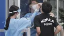 Seorang petugas medis mengambil sampel dari petugas polisi selama pengujian COVID-19 di Badan Kepolisian Metropolitan Seoul di Seoul, Korea Selatan, Rabu, (19/8/2020). (AP Photo / Ahn Young-joon)