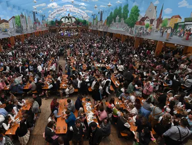 Pengunjung menikmati bir selama Festival Oktoberfest 2019 di sebuah tenda di Munich, Jerman selatan (3/10/2019). Festival bir terbesar di dunia Oktoberfest berlangsung hingga 6 Oktober 2019. (AFP Photo/Christof Stache)