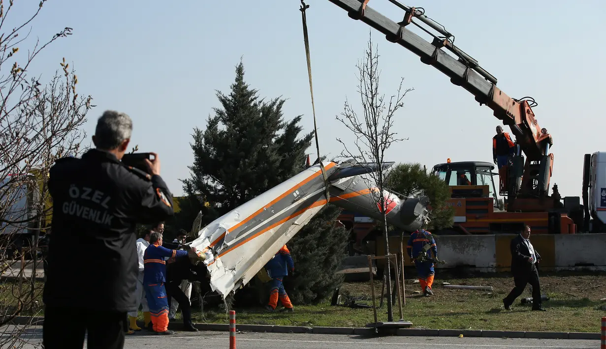 Alat berat dikerahkan untuk mengangkat puing helikopter yang hancur usai menabrak menara stasiun televisi, Turki, Jumat (10/3). Lima orang yang berada di dalamnya tewas seketika. (AP Photo)