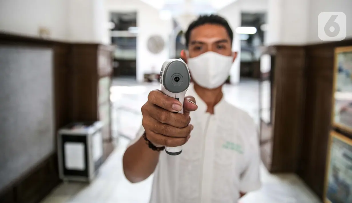 Petugas mengukur suhu tubuh di Masjid Cut Meutia, Jakarta, Kamis (30/7/2020). Masjid Cut Meutia akan menggelar Salat Idul Adha esok hari dengan menerapkan protokol kesehatan pencegahan Covid-19. (Liputan6.com/Faizal Fanani)