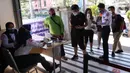 Petugas memeriksa Surat Tanda Registrasi Pekerja (STRP) bagi penumpang di Stasiun Tangerang, Banten, Senin (12/7/2021). Hari pertama penerapan STRP, masih ada warga yang tidak mengetahui persyaratan tersebut hingga membuat penumpang KRL menurun sekitar 30 persen. (Liputan6.com/Angga Yuniar)