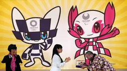 Ryo Taniguchi (kanan) menerima model 3D dari karakter maskot untuk Olimpiade dan Paralimpiade Tokyo 2020 yang dirancangnya di Tokyo, Jepang, Rabu (28/2). Maskot telah dipilih setelah pemungutan suara siswa SD di seluruh Jepang. (AP Photo/Eugene Hoshiko)