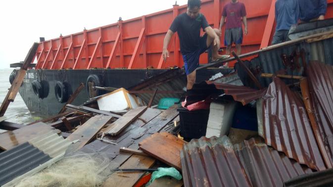 Kapal tongkang terhempas gelombang laut dan menghantam permukiman warga di Batam. (Foto: Liputan6.com/Ajang Nurdin)