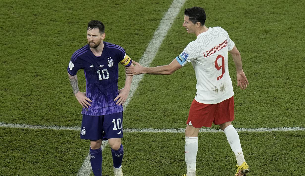 Seusai laga yang berkseudahan 2-0 untuk kemenangan Argentina yang sekaligus meloloskan keduanya ke babak 16 besar, Robert Lewandowski menghampiri Lionel Messi untuk memberikan selamat. (AP/Hassan Ammar)