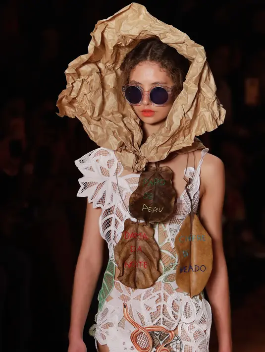 Seorang model mengenakan kertas cokelat atau yang biasa disebut kertas pembungkus di kepalanya saat membawakan rancangan karya Ronaldo Fraga dalam Sao Paulo Fashion Week di Brasil (26/4). (AP Photo / Andre Penner)