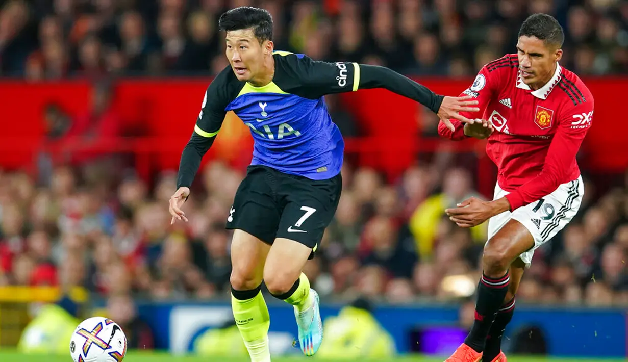 Pemain Tottenham Hotspur Son Heung-min (kiri) menggiring bola dari pemain Manchester United Raphael Varane pada pertandingan sepak bola Liga Inggris di Old Trafford, Manchester, Inggris, 19 Oktober 2022. Manchester United mengalahkan Tottenham Hotspur dengan skor 2-0. (AP Photo/Dave Thompson)