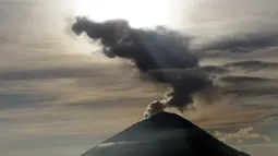 Embusan asap keluar dari kawah Gunung Agung ketika matahari terbit (sunrise) yang terlihat dari Kintamani, Bali, Rabu (13/12). BNPB menegaskan bahwa kondisi Pulau Bali aman bagi wisatawan meski Gunung Agung berstatus siaga. (AP Photo/Firdia Lisnawati)