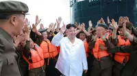 Pemimpin Korut, Kim Jong-un menyapa pasukannya sebelum tes tembakan rudal balistik dari kapal selam, Pyongyang (25/8). Peluncuran rudal disinyalir sebagai bentuk protes atas latihan militer gabungan Korsel-AS. (AFP PHOTO/KCNA)