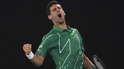 Petenis Serbia Novak Djokovic saat merayakan kemenangan set pertama melawan Milos Raonic dari Kanada selama pertandingan perempat final kejuaraan tenis Australia Terbuka di Melbourne, Australia, Selasa, (28/1/2020). (AP Photo/Lee Jin-man)