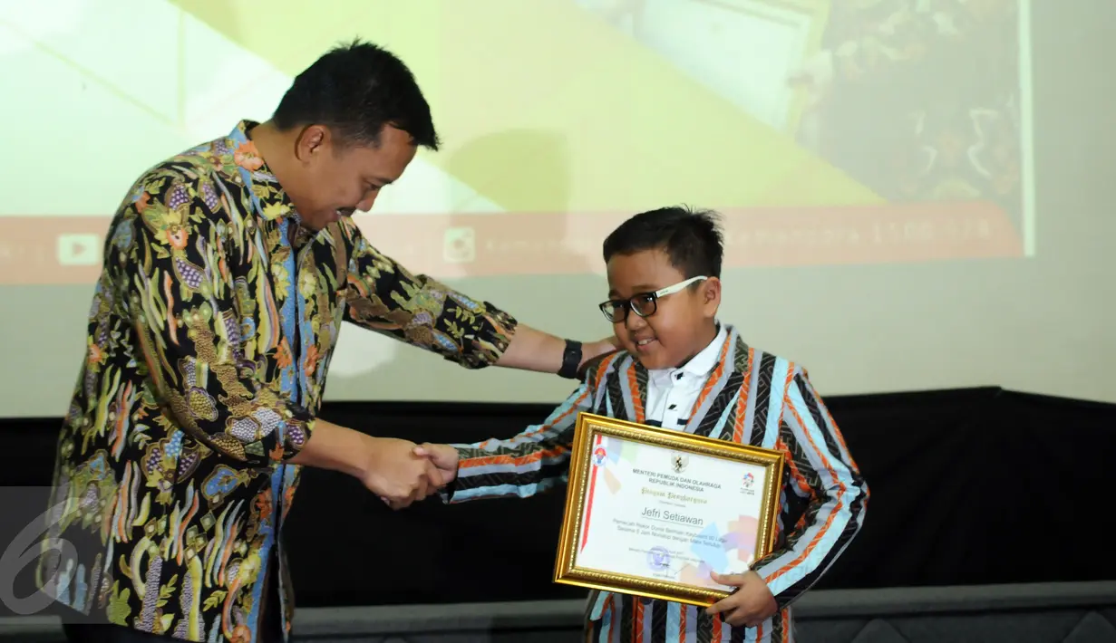 Menpora Imam Nahrawi menyerahkan penghargaan kepada Jefri Setiawan yang berhasil mencatat rekor dunia baru di Auditorium Kemenpora, Jakarta, Kamis (14/11). (Liputan6.com/Helmi Fithriansyah)