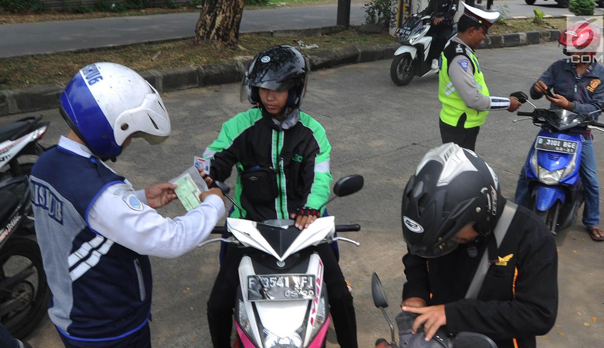 Petugas Polantas dan Dishub memeriksa kelengkapan surat pengendara dalam Operasi Zebra Jaya 2018 di kawasan Cinere, Depok, Selasa (30/20). Gelar operasi zebra ini bertujuan untuk menurunkan angka pelanggaran lalu lintas. (Merdeka.com/Arie Basuki)