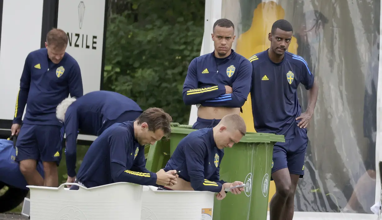 Pemain Swedia Albin Ekdal dan Ludwig Augustinsson duduk di pemandian es, setelah sesi latihan di Gothia Park Academy di Gothenburg, Swedia, Selasa (22/6/2021).  Laga ini menjadi penentuan bagi kedua negara agar bisa lolos ke babak 16 besar atau fase gugur. (Adam Ihse/TT News Agency via AP)
