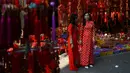 Dua wanita melihat-lihat dekorasi Tahun Baru Imlek atau perayaan Tet di sebuah pasar pusat Kota Tua Hanoi, Senin (28/1). Setiap perayaan imlek, warga Vietnam akan menghias rumah dengan berbagai dekorasi berwarna merah. (Manan VATSYAYANA/AFP)
