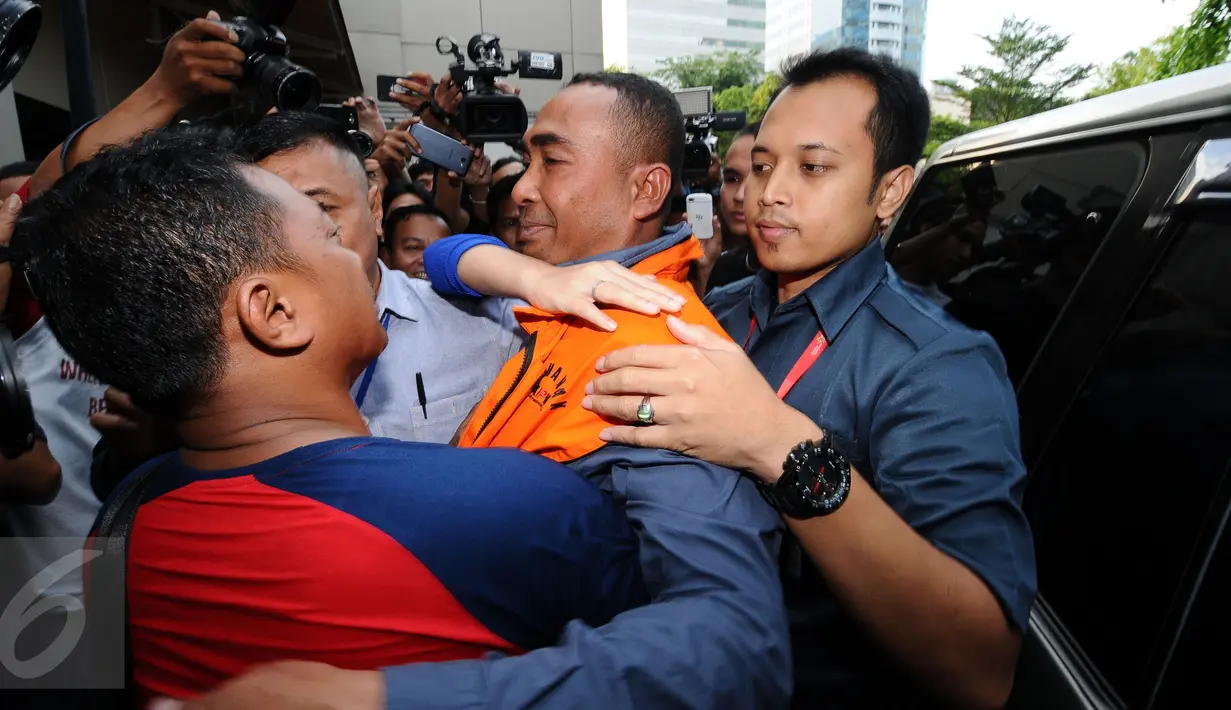 Bupati Buton nonaktif, Samsu Umar Abdul Samiun dipeluk kerabatnya jelang masuk ruang tahanan di Gedung KPK, Jakarta, Kamis (26/1). Samsu Umar tersangka dugaan suap Ketua Mahkamah Konstitusi Akil Mochtar, Oktober 2016. (Liputan6.com/Helmi Fithriansyah)