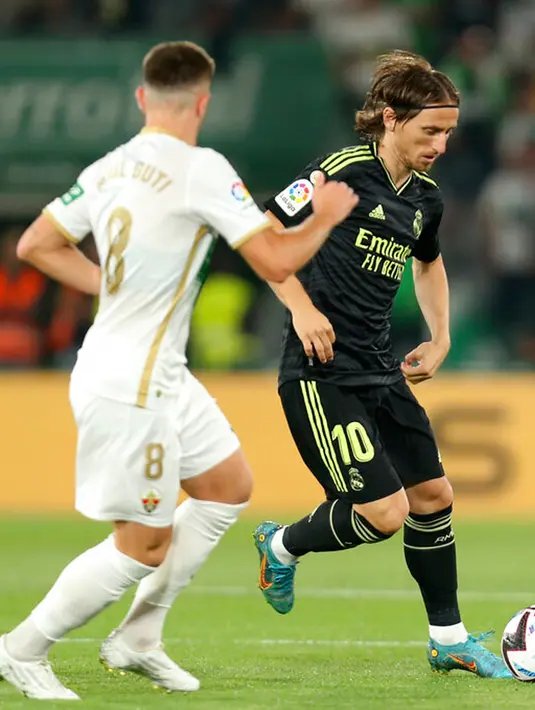 Pemain Elche Raul Guti (kiri) berebut bola dengan pemain Real Madrid Luka Modric pada pertandingan sepak bola La Liga Spanyol di Stadion Martinez Valero, Elche, Spanyol, 19 Oktober 2022. Real Madrid mengalahkan Elche dengan skor 3-0. (AP Photo/Alberto Saiz)