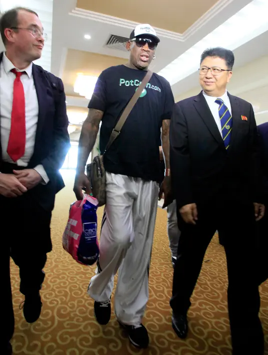 Mantan pemain Chicago Bulls, Dennis Rodman disambut oleh Wakil Menteri Kementerian Olahraga Korea Utara Son Kwang Ho, saat tiba di Bandara Internasional Sunan di Pyongyang, Korea Utara, (13/6). (Foto AP/Kim Kwang Hyon)