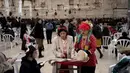 Kepemimpinan Wanita Tembok Yochi Rappeport (tengah) dan Rachel Cohen Yeshurun (kanan) membaca Kitab Ester selama Hari Raya Purim yang tahun ini bertepatan dengan Hari Perempuan Internasional di bagian wanita di Tembok Barat, Kota Tua Yerusalem, 8 Maret 2023. Kelompok ini telah melakukan perjuangan selama puluhan tahun untuk kesetaraan gender di tempat tersuci orang Yahudi dapat berdoa tersebut. (AP Photo/Maya Alleruzzo)