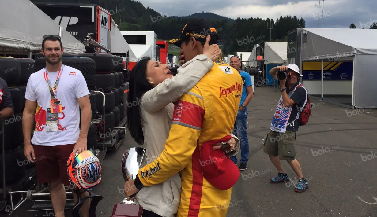 Pebalap Campos Racing asal Indonesia, Sean Gelael, menangis haru dalam pelukan sang ibu, Rini S. Bono, seusai finis posisi kedua feature race GP2 Austria di Sirkuit Red Bull Ring, Austra, Sabtu (2/7/2016). (Bola.com/Reza Khomaini)