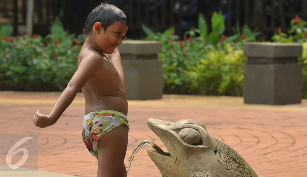 Seorang anak bermain air di Taman Kodok kawasan Menteng, Jakarta, Minggu (17/1/2016). Taman Kodok kerap dijadikan tempat bermain oleh sejumlah anak pada setiap hari libur. (Liputan6.com/Faisal R Syam)