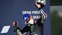 Maverick Vinales tetap gunakan masker ketika naik podium kedua MotoGP Jerez. (JAVIER SORIANO / AFP)