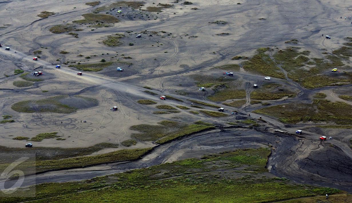 Puluhan kendaraan melintasi lautan pasir di kawasan Gunung Bromo, Taman Nasional Bromo Tengger Semeru, Jawa Timur, Kamis (21/7). Meski berstatus waspada, intensitas kunjungan ke Gunung Bromo justru meningkat. (Liputan6.com/Helmi Fithriansyah) 