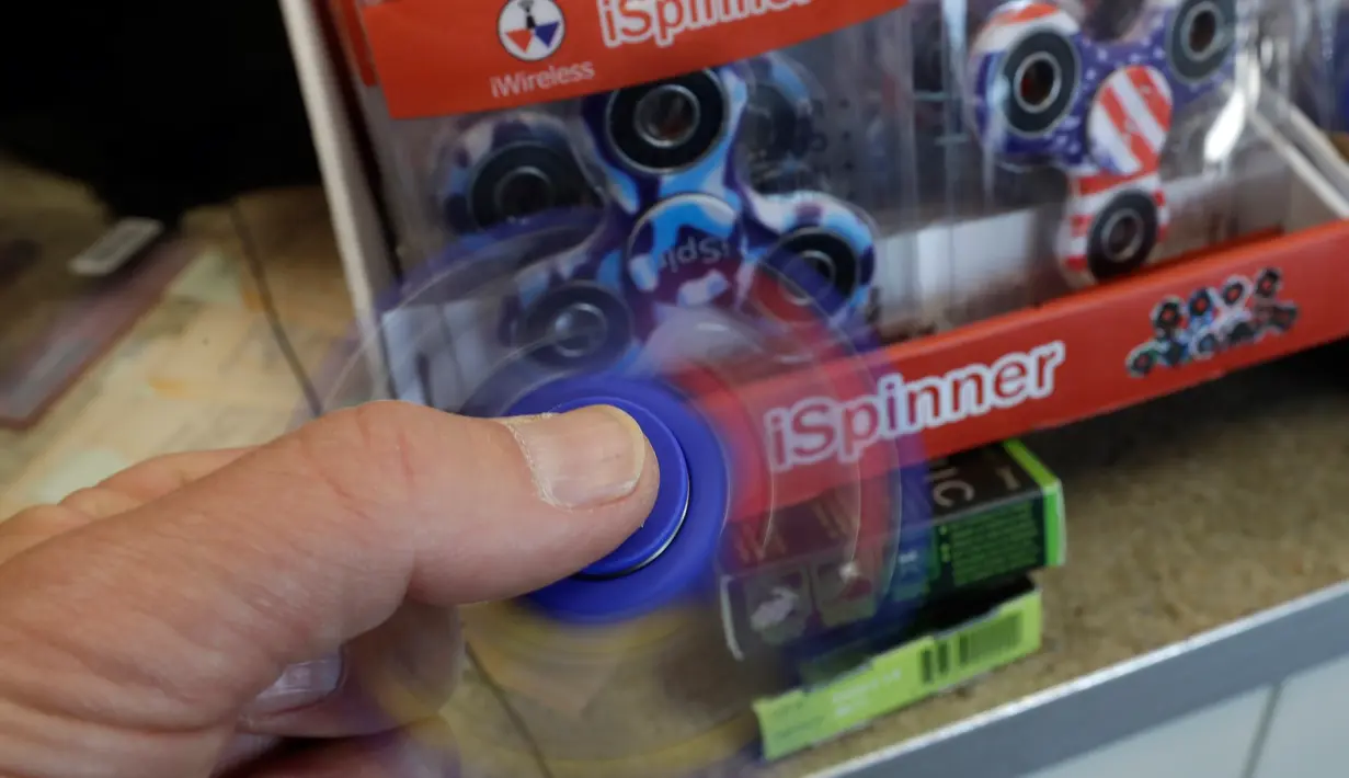 Fidget spinner dimainkan di sebuah yang bernama toko Funky Monkey Toys di Oxford, Mich (11/5). Secara umum, alat kecil seukuran jari ini dimainkan untuk mengusir rasa bosan atau cemas. (AP Photo / Carlos Osorio)