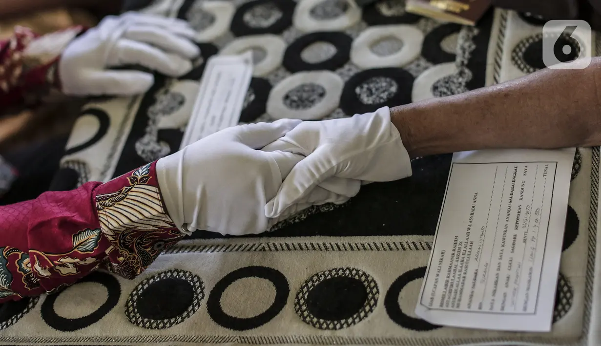 Prosesi akad nikah di KUA Pondok Pinang, Kebayoran Lama, Jakarta, Jumat (17/7/2020). Di masa PSBB transisi, pihak KUA menikahkan 8-10 pasangan per hari dengan mengikuti protokol kesehatan sesuai Surat Edaran Menteri Agama Nomor 15 Tahun 2020. (Liputan6.com/Johan Tallo)