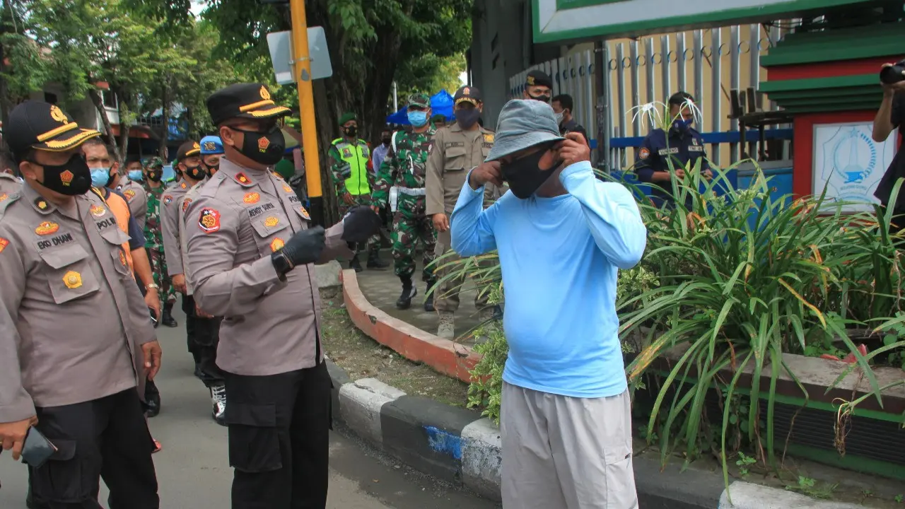 Petugas membagikan masker di Pasar dan terminal Bojonegoro. (Ahmad Adirin/Liputan6.com)