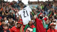 Suporter Portugal mengangkat jersey bertuliskan mendiang Diogo Jota saat menyaksikan laga Grup F Kualifikasi Piala Dunia 2026 antara Portugal melawan Armenia di Dragao Stadium, Porto, Minggu (16/11/2025) waktu setempat. (AP Photo/Luis Vieira)