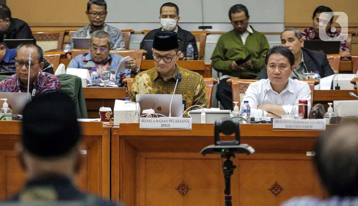 Dirjen Penyelenggaraan Haji dan Umrah (PHU) Hilman Latief (kanan) dan Kepala Badan Pengelola Keuangan Haji (BPKH) Fadlul Imansyah (tengah) menyampaikan paparan saat rapat dengar pendapat bersama Komisi VIII DPR di Kompleks Parlemen, Senayan, Jakarta, Selasa (14/2/2023). Pengumuman terkait besaran biaya haji terpaksa ditunda hingga besok lantaran pemerintah bersama Panja Komisi VIII DPR masih belum menemui kesepakatan. (Liputan6.com/Faizal Fanani)