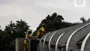 Pasukan kuning dari Dinas Bina Marga DKI Jakarta melakukan perawatan Jembatan Penyeberangan Orang (JPO) di Kawasan Sudirman, Senin (29/3/2021). Kegiatan tersebut dilakukan agar bersih terhidar dari debu serta para pemakai jembatan itu merasa aman dan nyaman. (Liputan6.com/Johan Tallo)