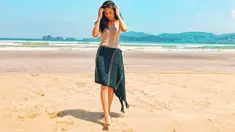 Penampilan dara kelahiran tahun 1997 ini sangat cerah saat berpose dengan latar belakang pantai pasir putih dan langit biru. Dengan baju berwarna putih dan Songket Bima berwarna gelap, tampak ia merapikan rambut hitamnya yang tergerai. (Liputan6.com/IG/indahpermatas)