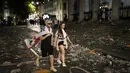 Dua pendukung timnas Inggris berjalan melewati sampah di sebuah jalan di pusat kota London, setelah Italia memenangkan pertandingan final EURO 2020, pada Minggu (11/7/2021). Usai pertandingan, jalan-jalan di London juga dipenuhi sampah. (AP Photo/Matt Dunham)