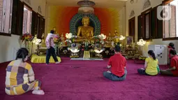 Sejumlah umat Buddha melakukan ibadah Hari Raya Tri Suci Waisak di Vihara Jakarta Dhammacakka Jaya, Rabu (26/5/2021). Pelaksanaan upacara Trisuci Waisak 2565/2021 dirayakan oleh umat Buddha secara terbatas dengan menerapkan protokol kesehatan secara ketat. (Liputan6.com/Faizal Fanani)